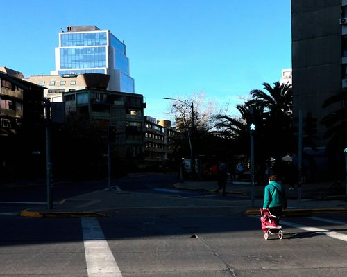 A professional walking down a city street during a sunny day in Chile